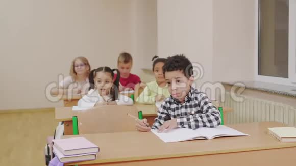 多种族儿童在教室里举手视频的预览图