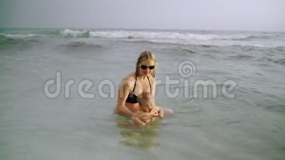 快乐的年轻母亲和她的小女孩在美国巴拿马城海滩的海水中玩得很开心视频的预览图