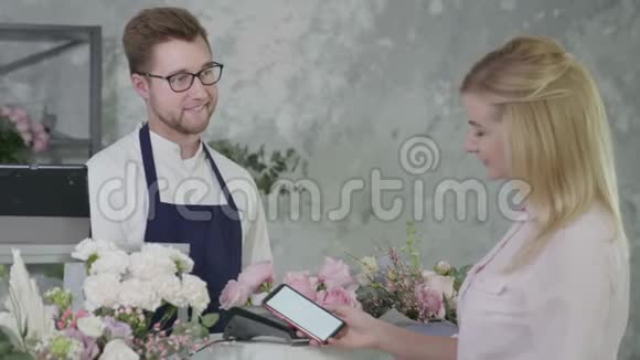 非接触式付款鲜花店男卖家向女买家以终端付款视频的预览图