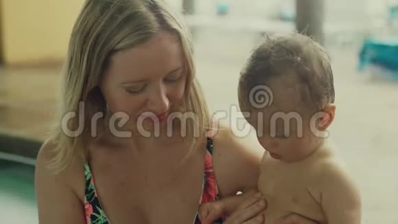 年轻的母亲和她的女婴在游泳池里视频的预览图