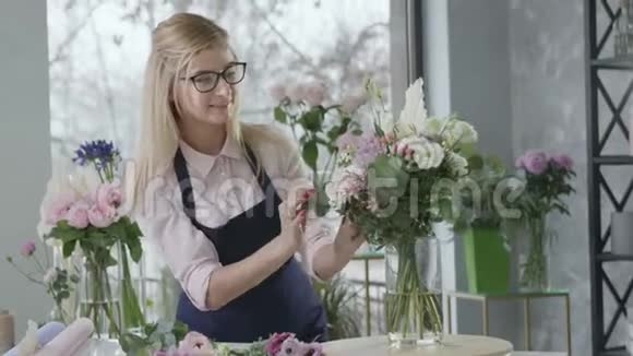 年轻的幸福女子花店做了一个现代花束在花店出售女企业家一个代表视频的预览图