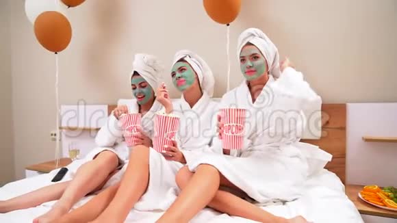 女孩们在床上吃爆米花玩得很开心视频的预览图