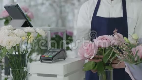 无联系付款满意的买家支付花束在现代花卉精品店在结帐终端使用视频的预览图