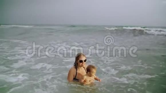 快乐的年轻母亲和她的小女孩在美国巴拿马城海滩的海水中玩得很开心视频的预览图