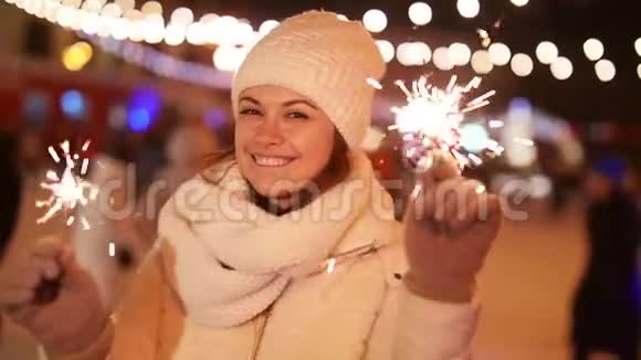 寒假概念年轻美丽快乐的微笑女孩拿着火花视频的预览图