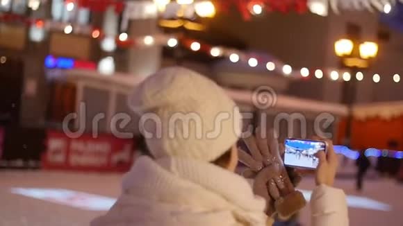 快乐女人在智能手机上拍摄欧洲圣诞市场场景视频的预览图