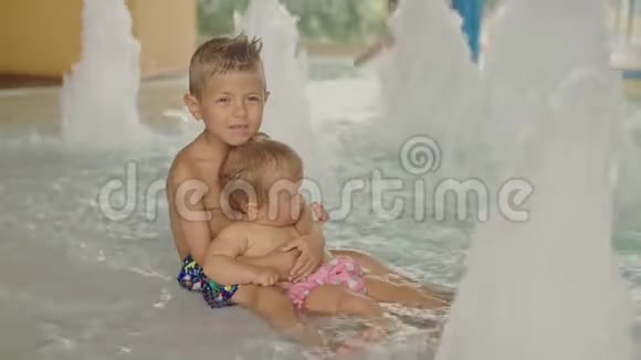 小男孩和小女孩在游泳池里玩得很开心哥哥和他妹妹在游泳池里玩视频的预览图