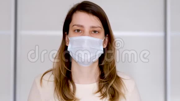 一名戴防护医疗面罩的年轻妇女的特写视频的预览图