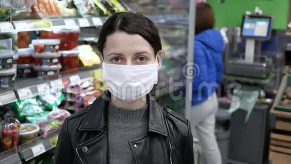 在杂货店戴医疗面具的年轻女子肖像大流行病视频的预览图