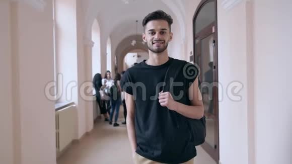 帅哥背着背包在大学礼堂摆姿势视频的预览图