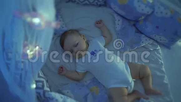 小婴儿睡在婴儿床上从上面看到的视频的预览图