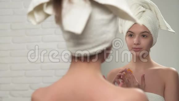 穿毛巾的女人在嘴唇上涂油膏视频的预览图