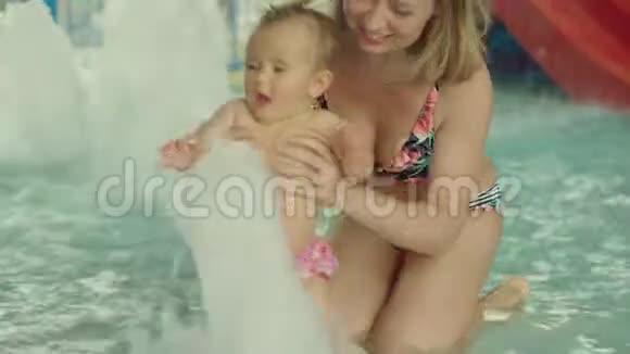 年轻的母亲和她的女婴在游泳池里视频的预览图