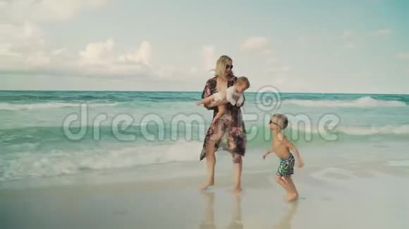 年轻漂亮的母亲和她的孩子们沿着海滩散步美国佛罗里达州巴拿马城海滩视频的预览图