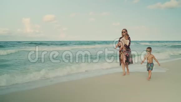 年轻漂亮的母亲和她的孩子们沿着海滩散步美国佛罗里达州巴拿马城海滩视频的预览图