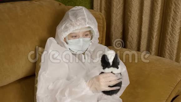生病的青少年女孩穿着保护服装在家沙发上玩仓鼠同时被隔离患病女孩感染视频的预览图