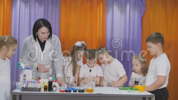 儿童化学实验男孩在一杯清澈的液体中加入绿色的水滴房间里弥漫着人造烟雾视频的预览图