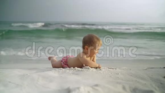 可爱的小女婴在海边靠近海浪美国巴拿马城海滩视频的预览图