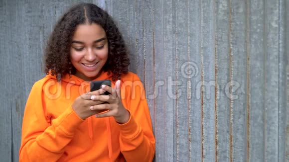 非裔美国少女使用智能手机或手机社交媒体的年轻女性视频的预览图
