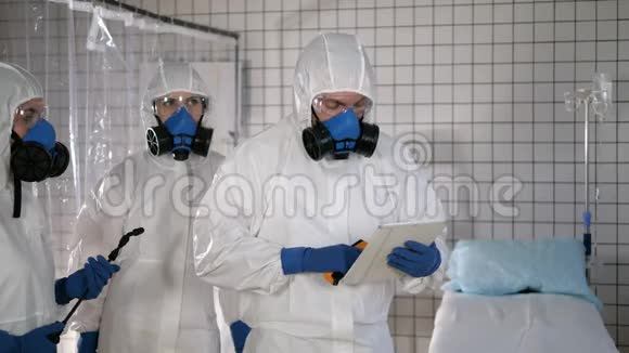 一支身穿防护服的队伍在医院里测量一名平民男子的体温冠状病毒COVID19视频的预览图