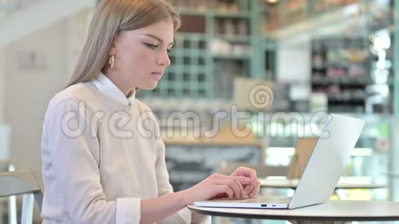 咖啡馆里的年轻女子在笔记本电脑上生气视频的预览图