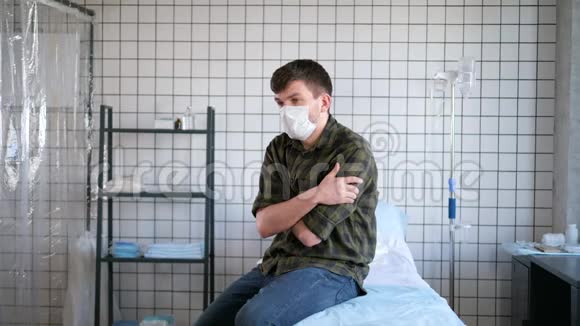 年轻男子戴着防护面罩独自坐在医院的房间里等待化验结果冠状病毒隔离视频的预览图