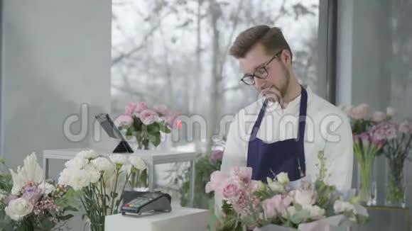 年轻的专业花商男女在花店工作创造一束美丽的鲜花快乐视频的预览图