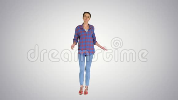 穿牛仔衬衫的休闲女人跳舞在渐变背景上看着相机视频的预览图