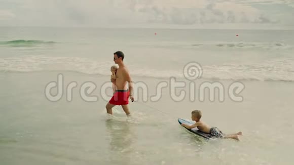 快乐的父亲和他可爱的孩子在美国巴拿马城海滩玩视频的预览图