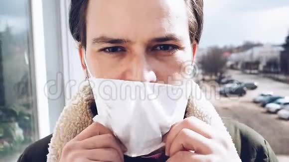 一名男子摘下医用呼吸面罩以防止COVID19冠状病毒的流行视频的预览图