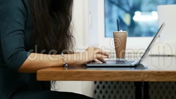 现代商务女性的双手特写在咖啡馆里坐着用触摸板在笔记本电脑上工作视频的预览图