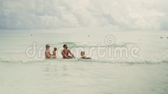 快乐的年轻家庭在巴拿马城海滩的海水中嬉戏视频的预览图