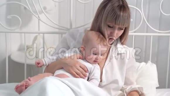 一位母亲带着婴儿在床上用电脑工作视频的预览图
