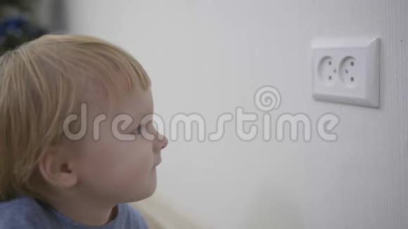 好奇的孩子有危险小男孩试图把手指插入家里的电器插座特写视频的预览图