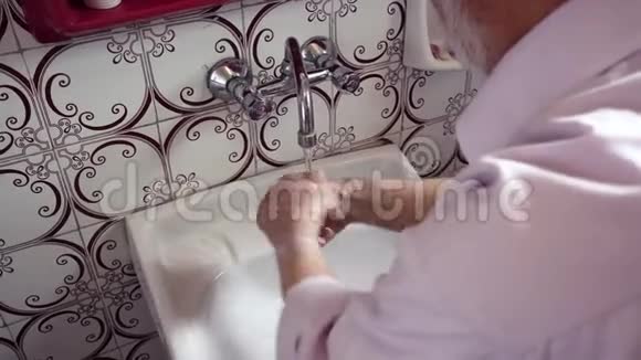 土耳其老人在复古浴室洗手的倾斜镜头视频的预览图