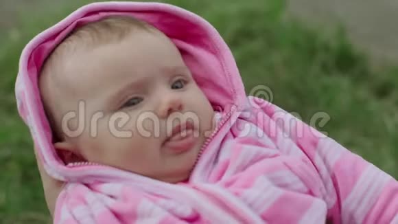 妈妈手上的小女婴在绿色的夏日公园放松绿色的背景视频的预览图