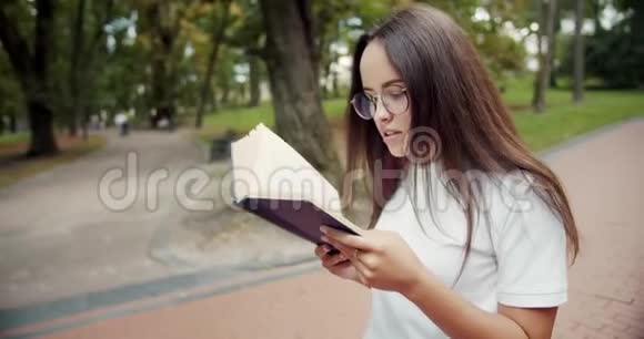 在公园打书的学生女孩视频的预览图
