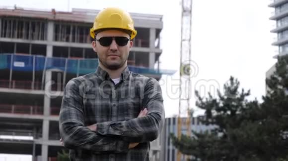 年轻帅气的工程师戴着安全帽戴着太阳镜看着镜头视频的预览图