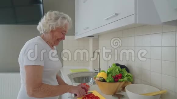 高级妇女在厨房做沙拉视频的预览图