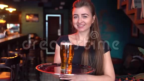 微笑的女服务员端着满满一杯啤酒的托盘视频的预览图
