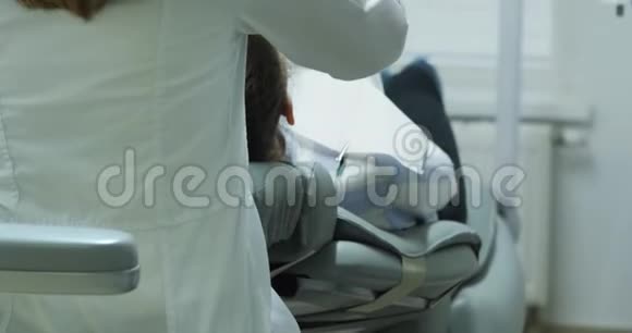 女性牙医使用显微镜视频的预览图