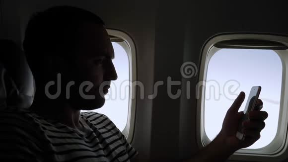 在飞机上用电话看书的人视频的预览图