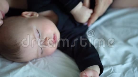 特写镜头穿黑衣服的妈妈和宝宝睡在一起视频的预览图