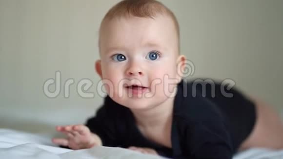 穿着黑衣服的婴儿躺在白床板上视频的预览图
