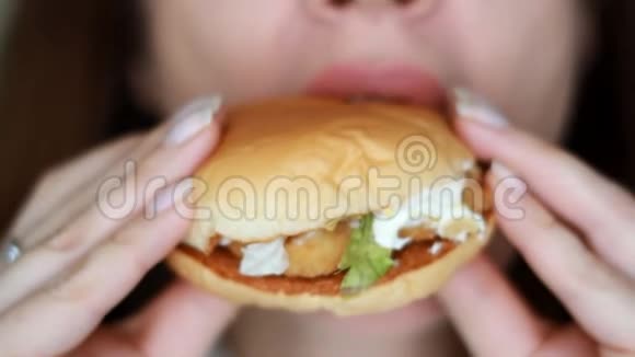 饥饿的女人吃汉堡包口和食物特写吃快餐女性手中的汉堡选择性重点视频的预览图
