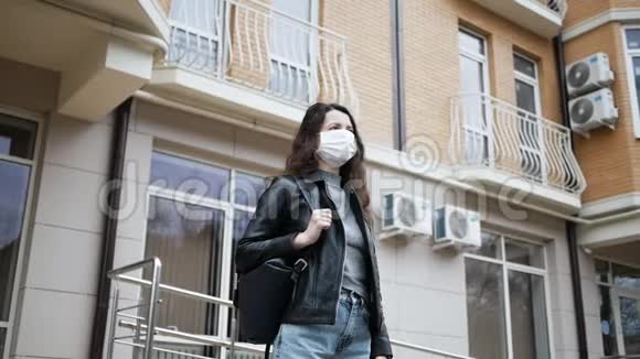 4戴着医用防护面罩的年轻女子站在家门口由于流行冠状病毒她不敢四处走动视频的预览图