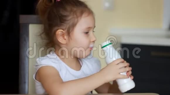 儿童饮用一瓶牛奶饮料kefir乳制品小女孩微笑着露出白胡子视频的预览图