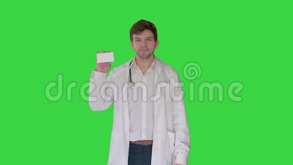行走的男医生在绿色屏幕上显示空的白色药丸盒色度键视频的预览图