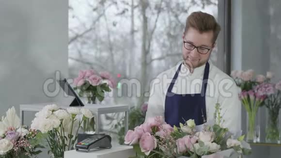 年轻的成功男性企业家两性平等代表在花店工作出售玫瑰花束视频的预览图