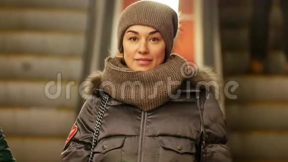 穿冬装的女人微笑着站在地铁站大堂视频的预览图